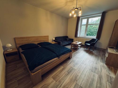 a bedroom with a bed and a living room at Apartmány Havířská Žacléř, Krkonoše in Žacléř