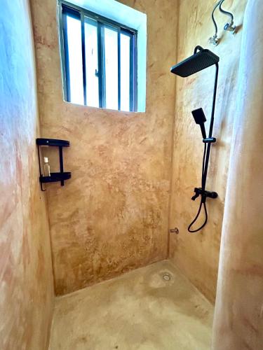 a room with a shower with a window and a lamp at Alcyone Residence - Ocean View Villa in Muyuni