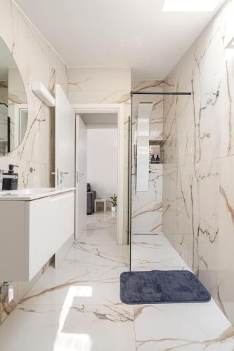 a bathroom with marble walls and a walk in shower at Casa Moniga 2-Residenze Lizzeri in Moniga