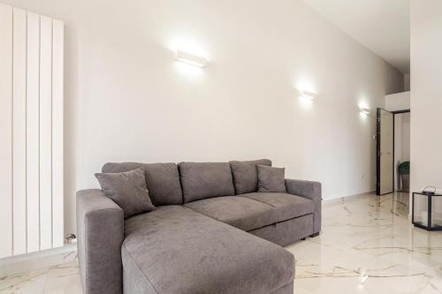 a couch in a living room with a white wall at Casa Moniga 2-Residenze Lizzeri in Moniga