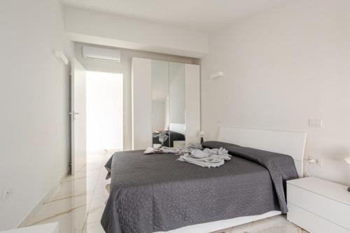 a white bedroom with a bed and a mirror at Casa Moniga 2-Residenze Lizzeri in Moniga