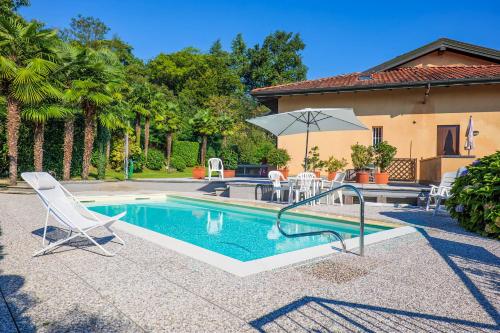 a swimming pool with a chair and an umbrella at Residenz Vogino in Baveno