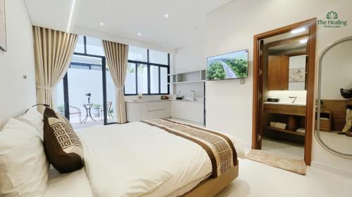 a bedroom with a bed and a sink and a mirror at The Healing Luxury Hotel in Buon Ma Thuot