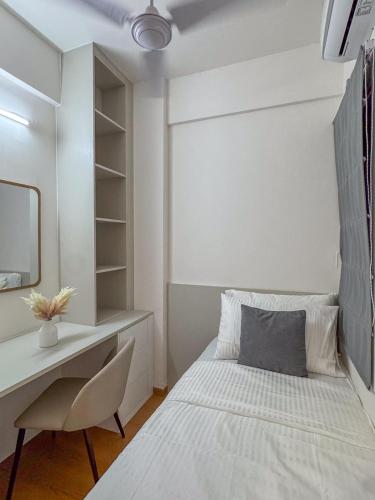 a white bedroom with a bed and a desk at Lux Stay in Hulhumale