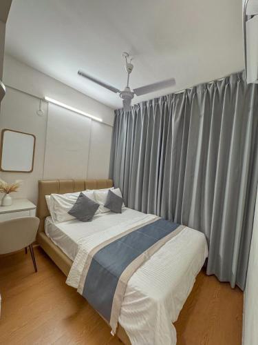 a bedroom with a bed and a window with curtains at Lux Stay in Hulhumale