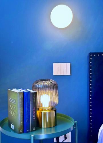 a table with books and a lamp on it at MilanLife Apartments - DTown Charme in Milan