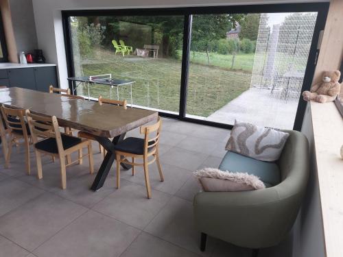 a dining room with a table and chairs and a large window at Champs Erezée , genieten in elk seizoen in Érezée