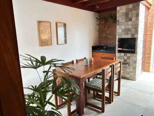 una cocina con una mesa de madera y una planta en Casa Aloha, en São Miguel do Gostoso