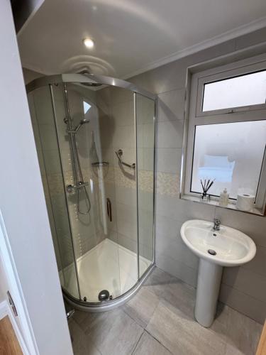 un baño con ducha y lavabo en Charlie Óg's Bridge House, en Dungloe