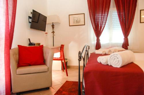 a bedroom with a bed and a chair and a television at Villa Giummarito in Scicli