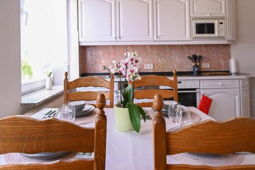 a kitchen with a table with a vase of flowers on it at Mahesars Home 2 in Ennepetal