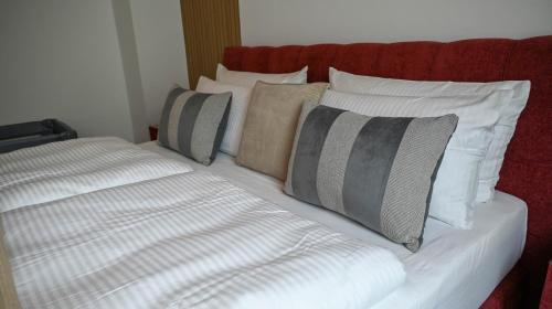 a bed with white pillows and a red headboard at Mahesars Home 2 in Ennepetal