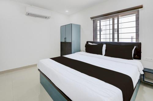 a large bed in a room with a large window at Hotel O Viraj Luxury Stay in Warangal