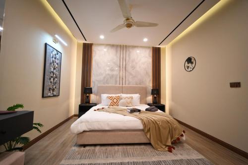a bedroom with a bed and a ceiling fan at Luxury 1BR Designer Condo at Zeta Mall Islamabad Balcony, Parking & Steps from Giga Mall in Islamabad