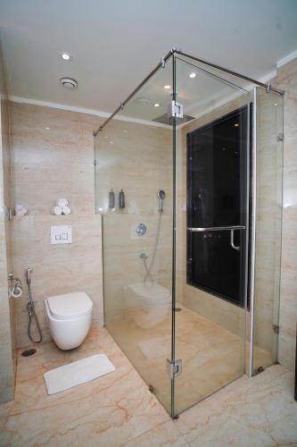 a bathroom with a glass shower with a toilet at Pride Hotel & Convention Centre Indore in Indore