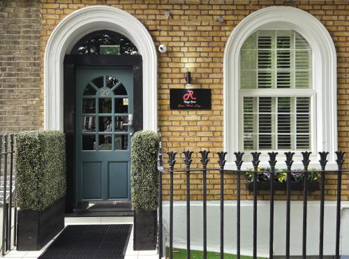 a blue door on a brick house with a fence at The Rokxy Townhouse & Residences - Kings Cross in London