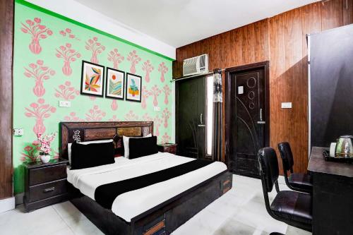 ニューデリーにあるHotel O Singhのベッドと緑の壁のある寝室