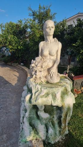 a statue of a man sitting on a rock at La casa dell'artista in Ardea