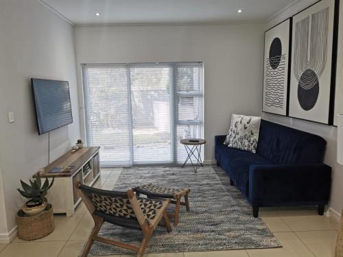 a living room with a blue couch and a table at Anyomi Zen in Gqeberha