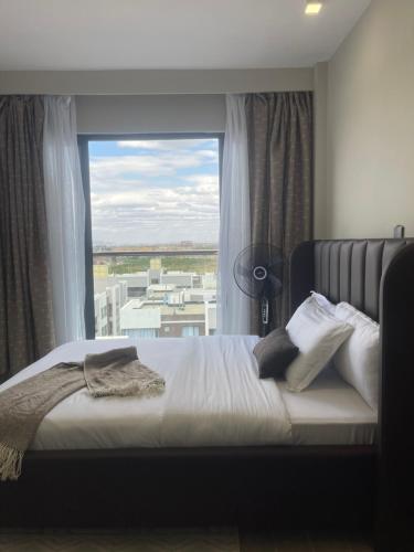 a bedroom with a bed with a large window at Hideaway holiday in Nairobi