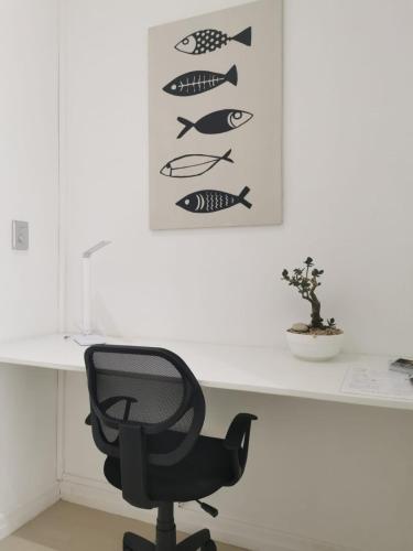 a desk with a chair and a picture of fish at Anyomi Zen in Gqeberha