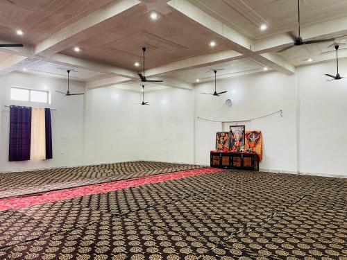 an empty room with a large room with a carpet at Sankant Mochan Ashram in Toda Bhīm