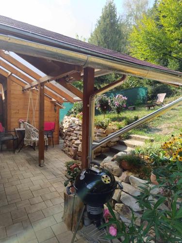 a wooden pergola with a grill in a garden at LélekZug Mátra in Parádsasvár