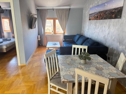 a living room with a table and a blue couch at Aleksei Apartmani in Belgrade