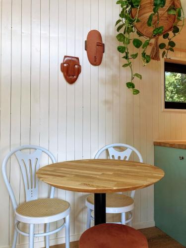 a wooden table and two chairs in a kitchen at Cozy Tiny House in the forest with spacious private garden in Zuidwolde
