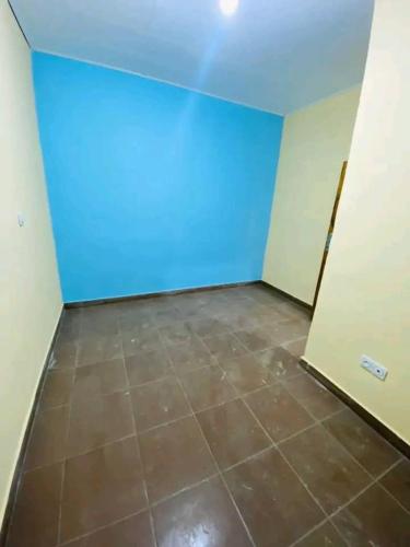 an empty room with blue walls and a tile floor at Maldrix1 in Bassa