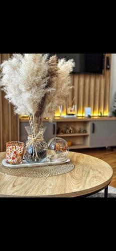 a table with a vase filled with feathers on it at Palace 19 in Zlatibor