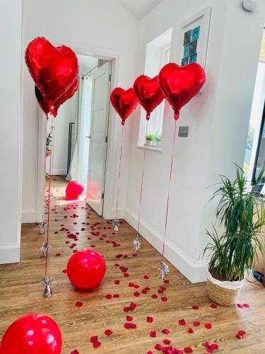a room filled with red hearts on the floor at The Cuckoo's Retreat - Luxurious home with private garden & jacuzzi in Kenwyn
