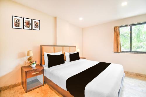 a bedroom with a large bed and a window at Townhouse OAK Hotel Naman Studio in Varanasi