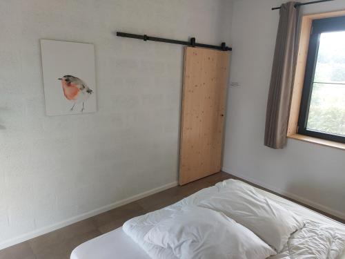 a bedroom with a bed and a bird on the wall at Champs Erezée , genieten in elk seizoen in Érezée