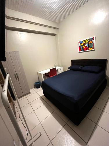 a bedroom with a bed and a table in it at Pousada DL in Pelotas