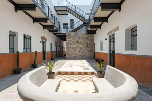 a courtyard with two white benches in a building at Casa 212 con WIFI alta velocidad y estacionamiento in Puebla