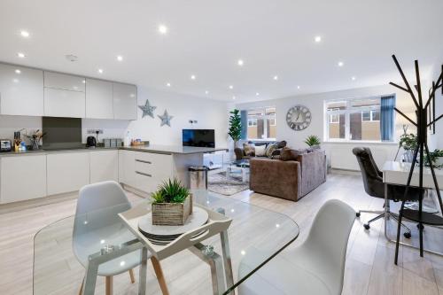 a kitchen and living room with a table and chairs at St Martins 2 Bedroom Apartments in Ruislip By 360 Stays in Ruislip