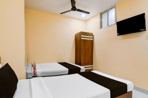 a bedroom with two beds and a flat screen tv at FabHotel Philips in Kolkata