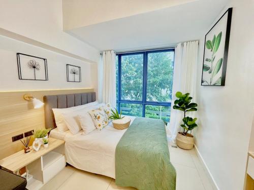 ein Schlafzimmer mit einem Bett und einem Fenster in der Unterkunft City Garden Inside IT Park Gym & Pool Fast Wi-Fi in Cebu City
