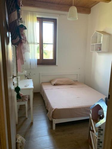 a bedroom with a bed and a table and a window at Podere MiaMa in Ripalta
