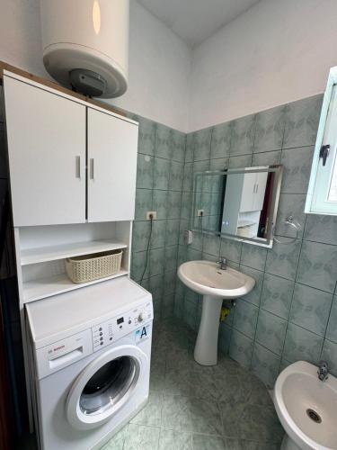 un bagno con lavatrice e lavandino di Dajanas apartment a Këlcyrë