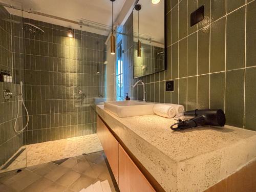 une salle de bain avec un lavabo, une douche et un miroir dans l'établissement Uma Ugeng Cemagi 2 BR, à Cemagi