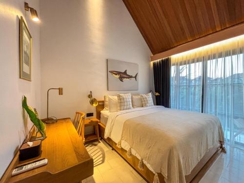 une chambre avec un lit et une grande fenêtre dans l'établissement Uma Ugeng Cemagi 2 BR, à Cemagi