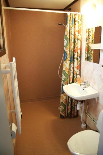 a bathroom with a sink and a shower curtain at Ekesberget Stugby stuga 15 in Ekshärad