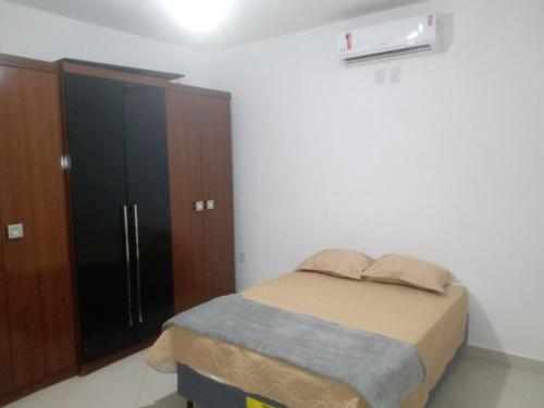 a bedroom with a bed and a black cabinet at Chácara da Nina - Itatiba in Itatiba