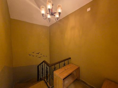 a room with a staircase with a table and a chandelier at Hotel Manjula INN in Mahabalipuram