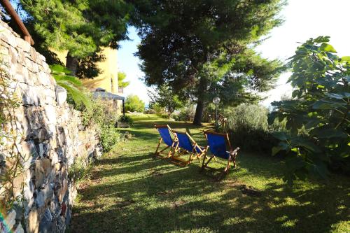 two chairs sitting in the grass next to a stone wall at Antico Portale in Ascea