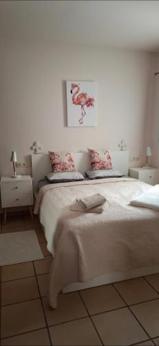 a white bedroom with a large bed with pink pillows at Casa Flamingolf Apartment in Fuente Alamo