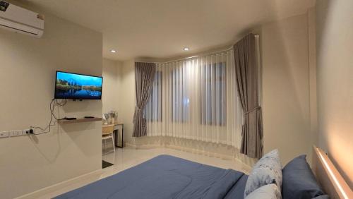 a bedroom with a bed and a flat screen tv at La-ngu Homie in Langu