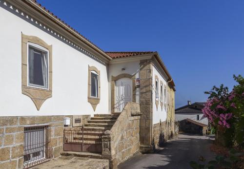 a white house with stairs and a gate at Casa da Câmara in Tondela